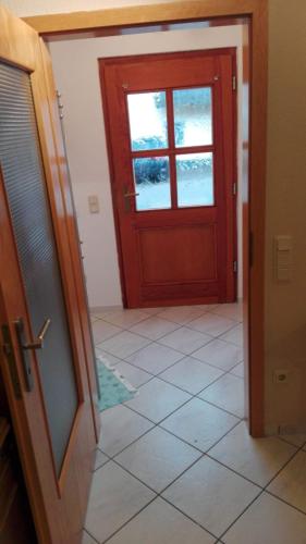 a room with a red door and a tile floor at Ferienwohnung Bermbach in Weilburg