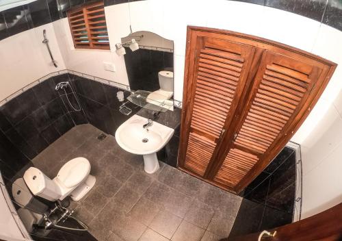 a bathroom with a toilet and a sink at Araliya Gardens Hotel in Hikkaduwa