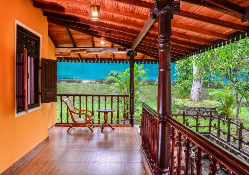 a balcony of a house with a table and a chair at Araliya Gardens Hotel in Hikkaduwa