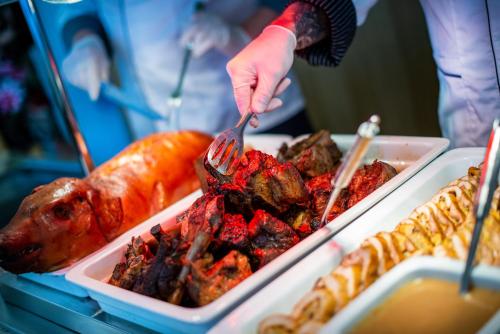a person eating food with a fork and knife at Spa Hotel Diana in Františkovy Lázně