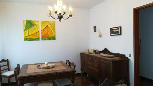a dining room with a table and a chandelier at Villa Praia in São Martinho do Porto