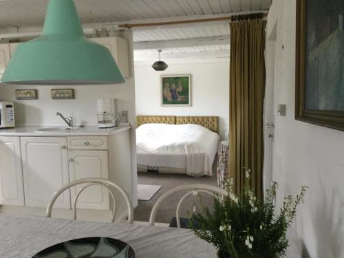 eine Küche mit einem Zimmer mit einem Bett und einer grünen Lampe in der Unterkunft Hotel Vestkysten in Løkken
