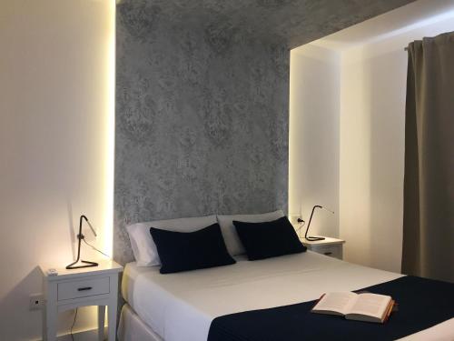 een slaapkamer met een bed met twee lampen en een boek erop bij Villalia Patricia in Playa Blanca