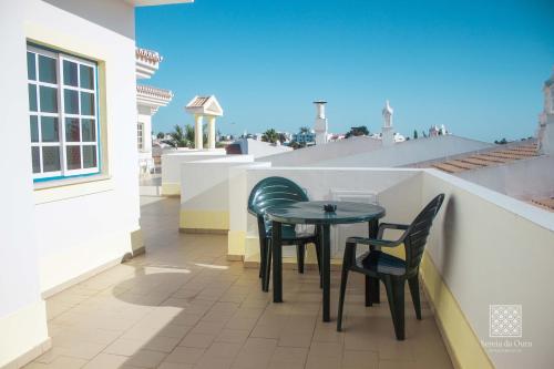 a table and chairs on the balcony of a house at Apartamentos Sereia da Oura in Albufeira
