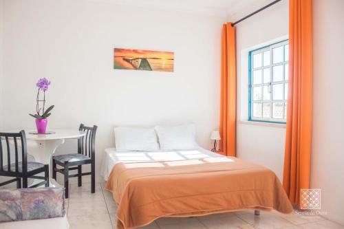 sypialnia z łóżkiem, stołem i oknem w obiekcie Apartamentos Sereia da Oura w Albufeirze