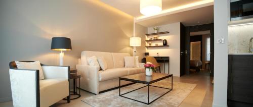 a living room with a couch and a table at Hôtel Roi de Sicile - Rivoli in Paris