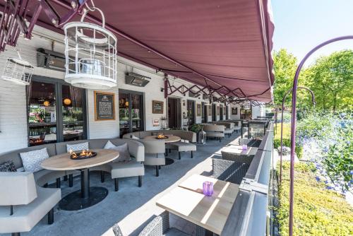 an outdoor patio with tables and chairs at Charmehotel Klokkenhof in Brasschaat