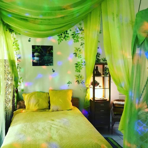 - une chambre dotée d'un lit avec des rideaux verts dans l'établissement Villa Romaine & Spa à Uzès, à Uzès