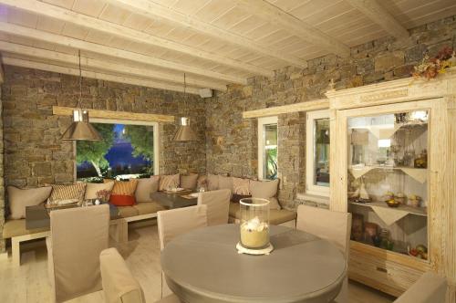 a dining room with a table and a stone wall at Vencia Boutique Hotel in Mýkonos City