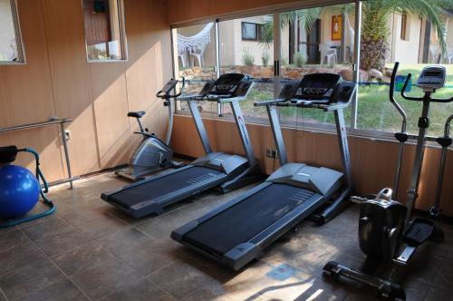 a gym with three treadmills and elliptical machines at Arapey Oasis Termal Hotel in Termas del Arapey
