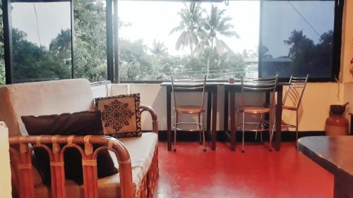 a living room with a table and chairs and windows at seaway's inn in Cochin