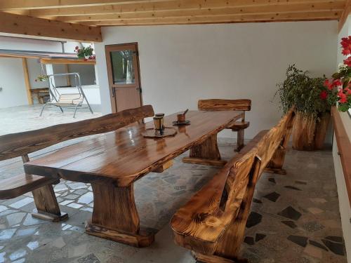 a large wooden table and benches in a room at Casa da Emanuela in Drežnik Grad