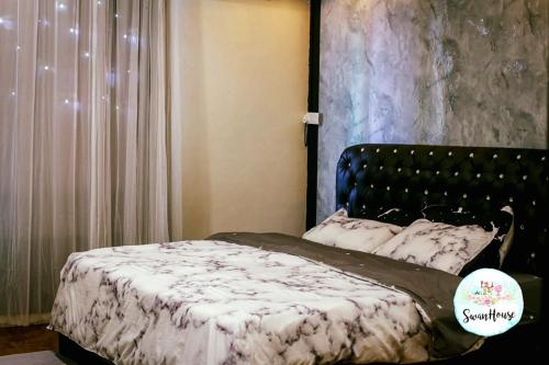 a bedroom with a bed with a black and white blanket at Sibu Swanhouse NO.IV (Full House) in Sibu