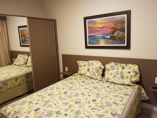 um quarto com duas camas e um quadro na parede em Park Veredas em Rio Quente