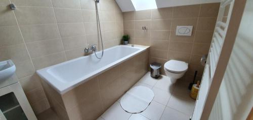 a bathroom with a tub and a toilet and a sink at Penzion Dolní Dunajovice in Dolní Dunajovice