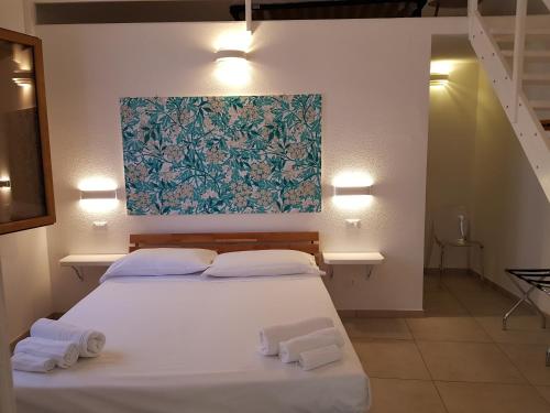 Un dormitorio con una cama blanca con toallas. en B. SINIS, en Cabras