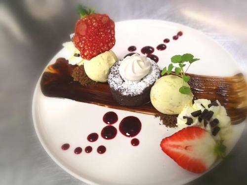 a plate of dessert with chocolate and fruit on it at Charmehotel Klokkenhof in Brasschaat