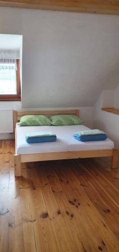 a large bed in a room with a wooden floor at Penzion Dolní Dunajovice in Dolní Dunajovice