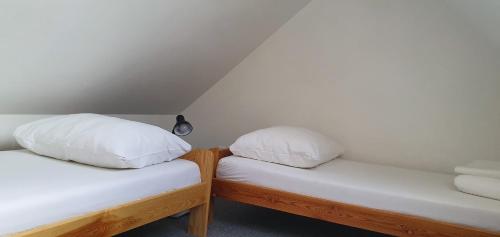 two beds with white pillows sitting next to each other at Penzion Dolní Dunajovice in Dolní Dunajovice