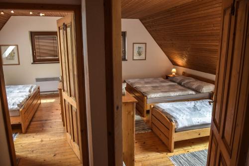 a room with three beds in a room with a staircase at Horská chata Stará Horáreň 1 in Dobšiná