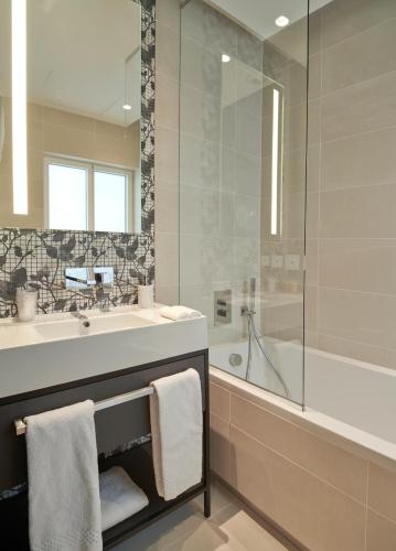 a bathroom with a sink and a shower and a tub at Hôtel Roi de Sicile - Rivoli in Paris