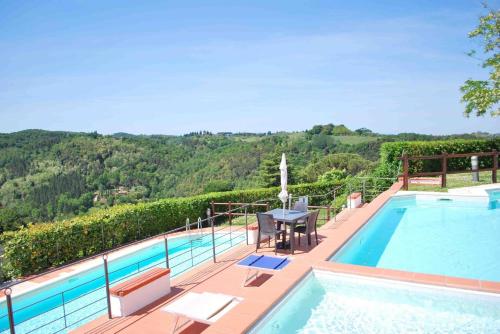 a swimming pool with a table and chairs next to at Borgo La Casaccia in Montaione