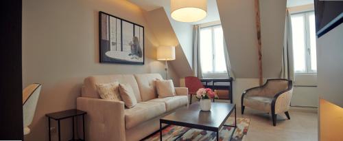 a living room with a couch and a table at Hôtel Roi de Sicile - Rivoli in Paris
