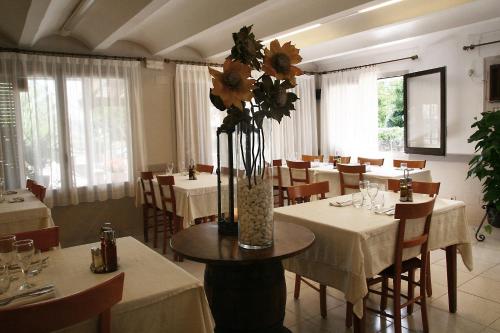 restauracja ze stołami i krzesłami z kwiatami w wazonie w obiekcie Carmelita w mieście Sant Privat de Bas
