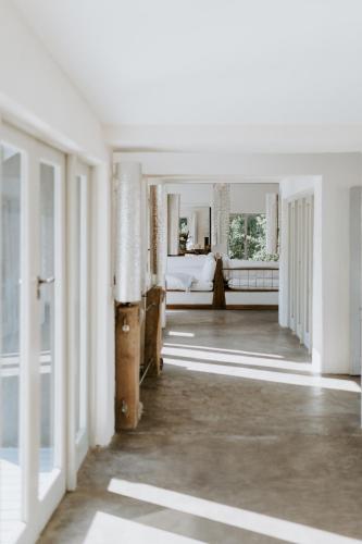 an empty hallway with a bed in a white room at Qambathi Mountain Lodge in Kamberg Valley