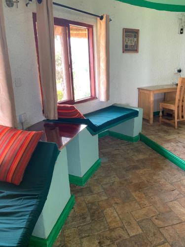 a living room with two benches and a table at Samuka Island Retreat in Jinja