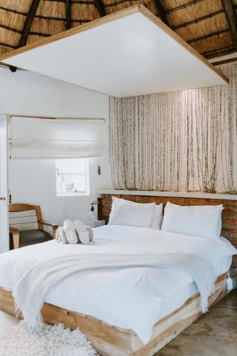 a bedroom with a large white bed with white pillows at Qambathi Mountain Lodge in Kamberg Valley