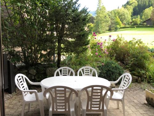 une table blanche et des chaises sur une terrasse dans l'établissement 2 pièces avec terrasse Morillon Village, à Morillon