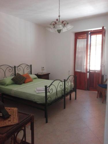 a bedroom with a green bed in a room at Casa della camperia in Favignana