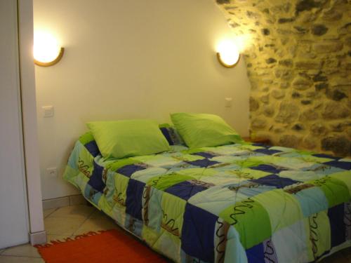 - une chambre avec un lit et des oreillers verts dans l'établissement Les jardins de la Volane, à Vals-les-Bains