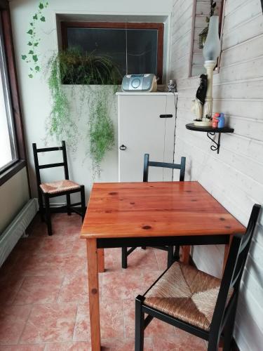 a table and chairs in a kitchen with a refrigerator at Romantic Studio Vacances in Labaroche