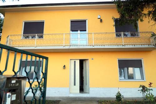 a yellow house with a balcony and a door at NOEMI & JULIENNE in Spineda