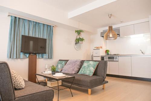 ein Wohnzimmer mit einem Sofa und einem Tisch in der Unterkunft LY INN Ryogoku Annex in Tokio
