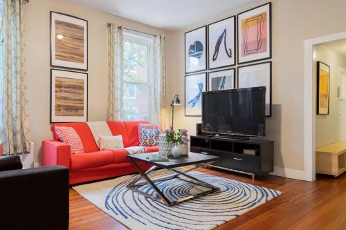 a living room with a red couch and a tv at Gorgeous Boston N End spacious 2Bd 1BA parking in Boston