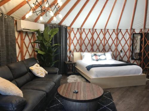 Escalante Yurts - Luxury Lodging في إيسكالانتي: غرفة مع سرير وأريكة في يورت