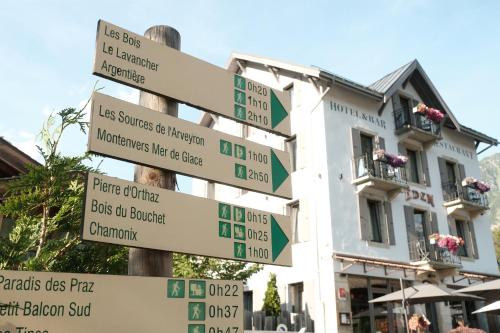 a pole with street signs in front of a building at Eden Hotel, Apartments and Chalet Chamonix Les Praz in Chamonix
