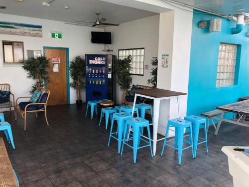 a bar with blue stools and a table and chairs at Chill Backpackers in Brisbane