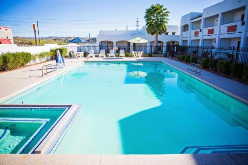 a large swimming pool with blue water in a hotel at Los Viajeros Inn in Wickenburg