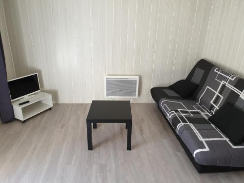 sala de estar con sofá y mesa en La mezzanine en Brassac-les-Mines
