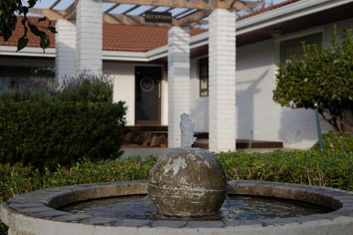 a fountain in front of a house with a house at Slaley Country House in Stellenbosch