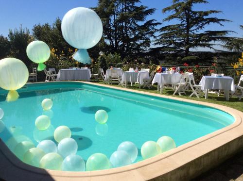 una piscina con globos, mesas y sillas en Villa Covaccioli Schimperna, en Formello