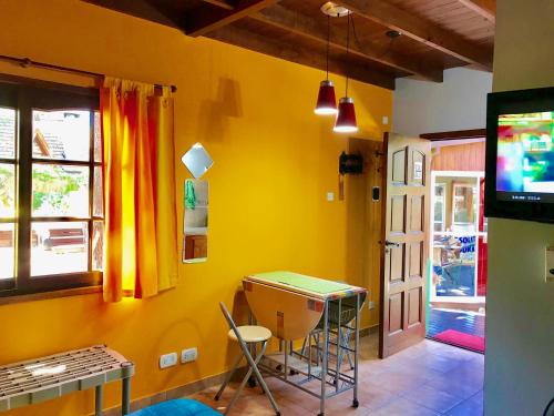 a room with a yellow wall with a table and chairs at B&B Mi Casa Es Tu Casa in Mar Azul