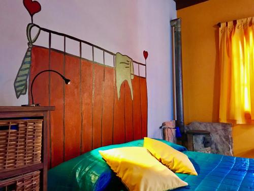 1 dormitorio con 1 cama con cabezal de madera y almohadas amarillas en B&B Mi Casa Es Tu Casa, en Mar Azul