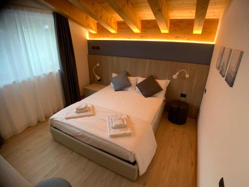 um quarto com uma cama com duas toalhas em Appartamenti Passuello Padola - Blue em Padola