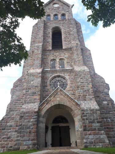 a tall brick building with a clock tower at Česlovos sodyba in Zarasai