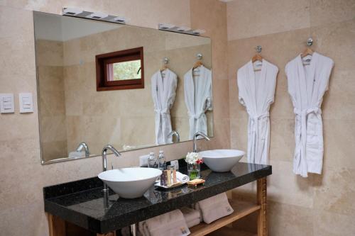a bathroom with two sinks and a large mirror at Tocuyeros Boutique Hotel in Cusco